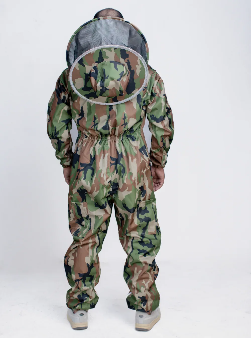 Back view of a beekeeper in a camouflage suit with the fencing veil zipped on, showing the veil zip and shoulders