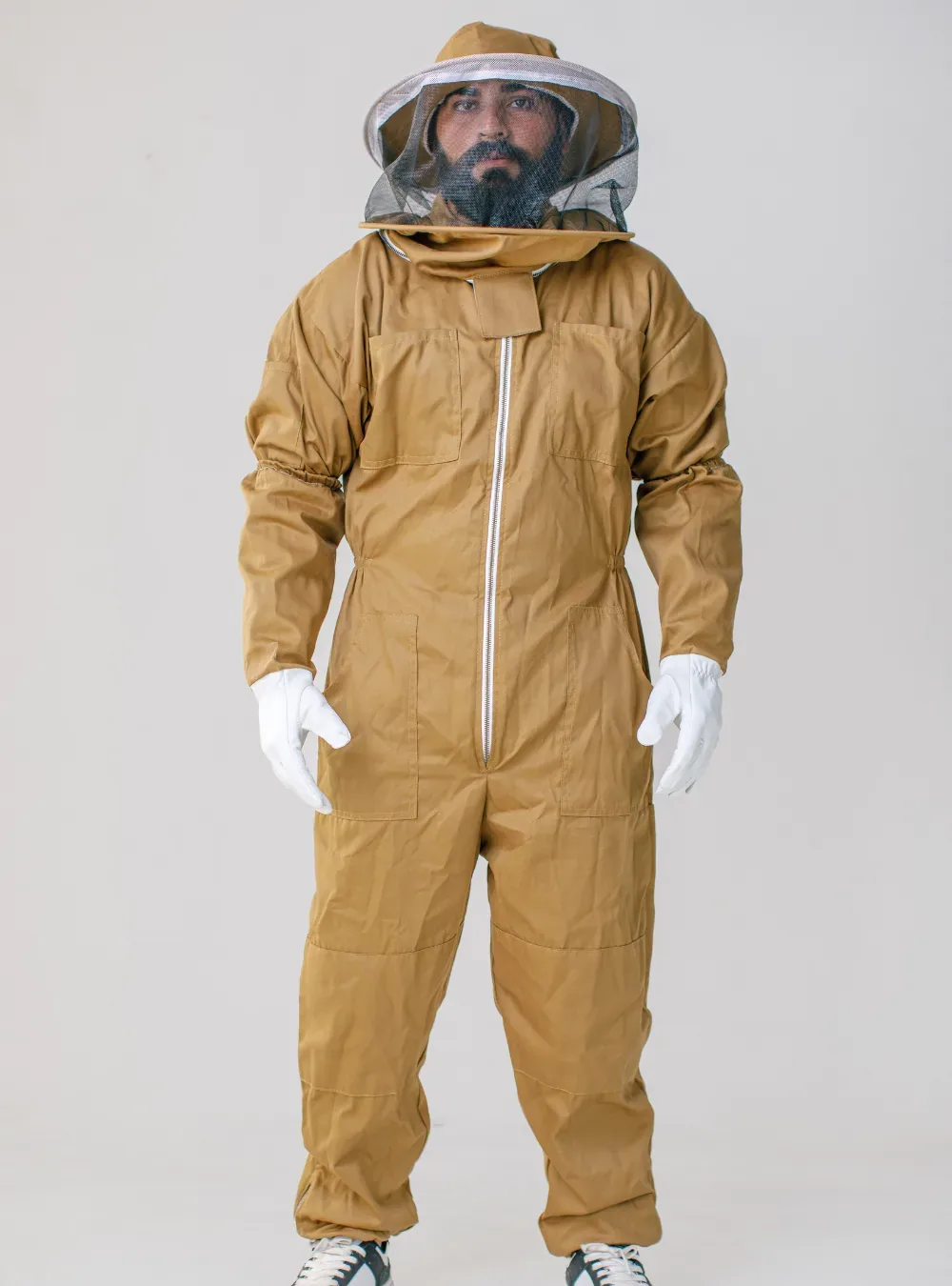 Beekeeper standing in a full brown cotton bee suit, front view, showing the full length from hood to ankle