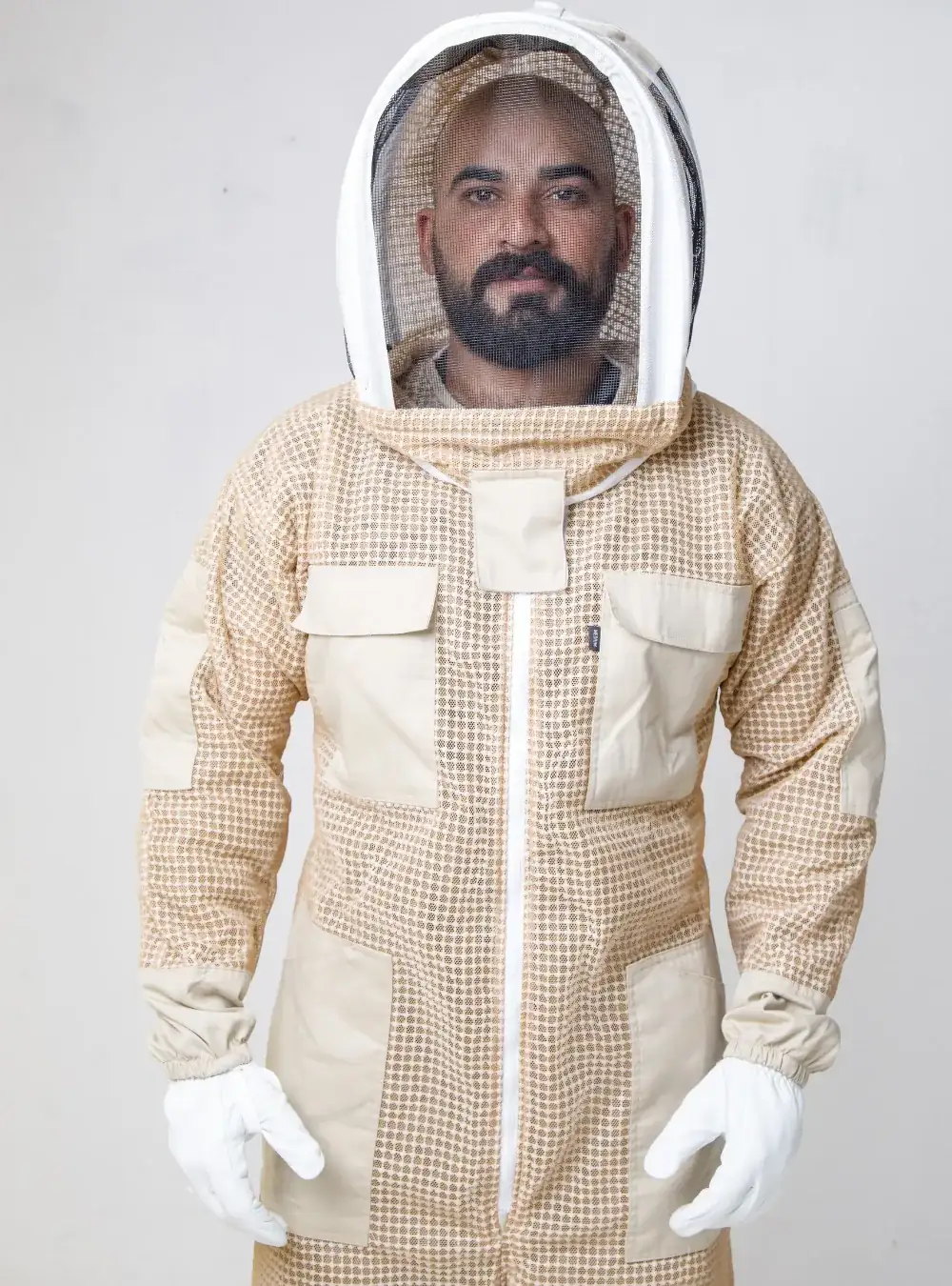Beekeeper in a tan three-layer ventilated beekeeping coverall with an attached fencing veil