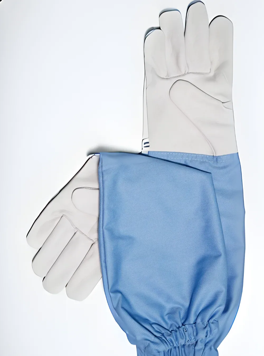 Close-up of a goatskin beekeeping glove and its blue cotton gauntlet, showing the grain and stitching