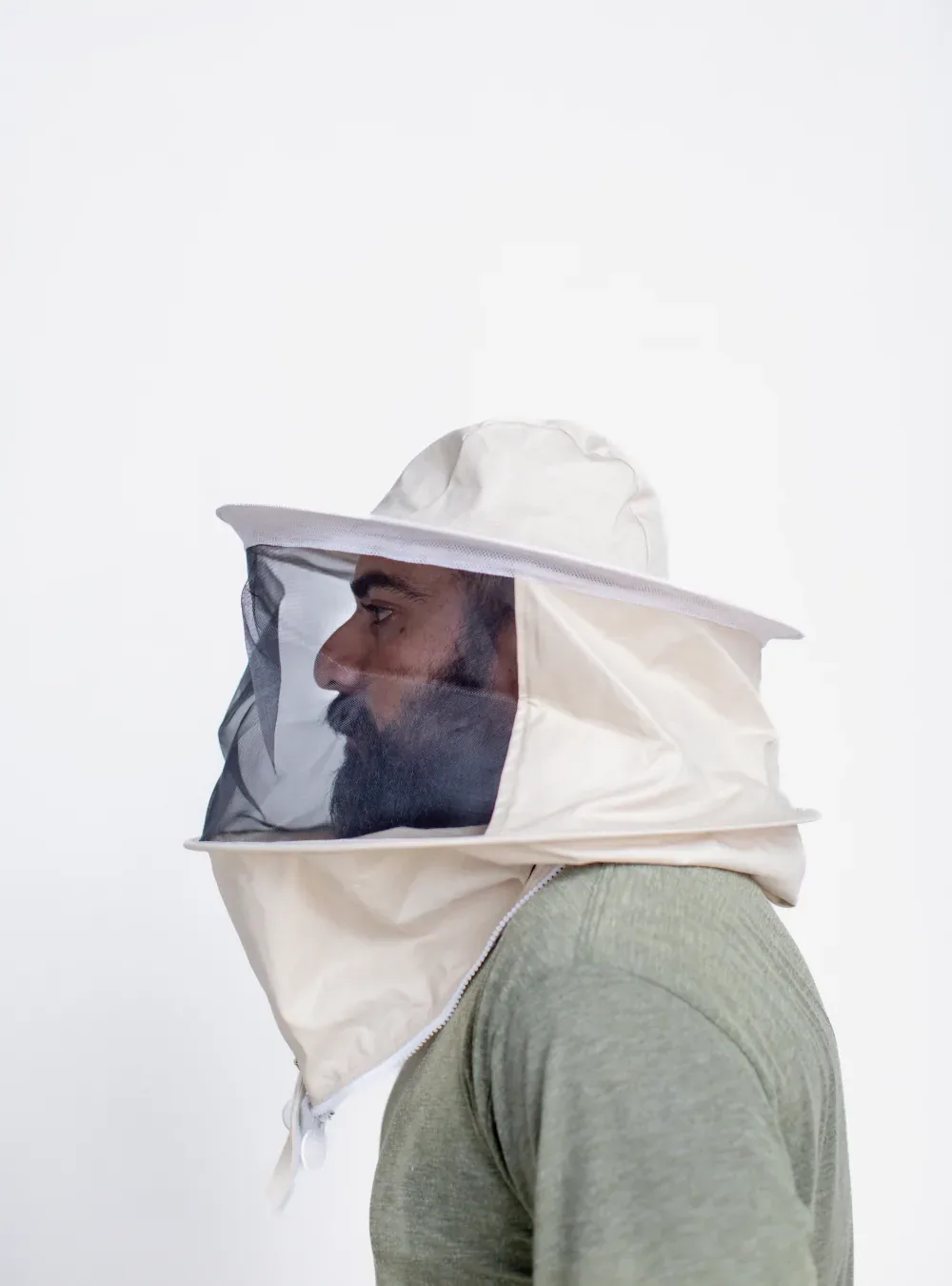 Side view of a beekeeper in a round hat veil, showing the gap the brim holds between the mesh and the face